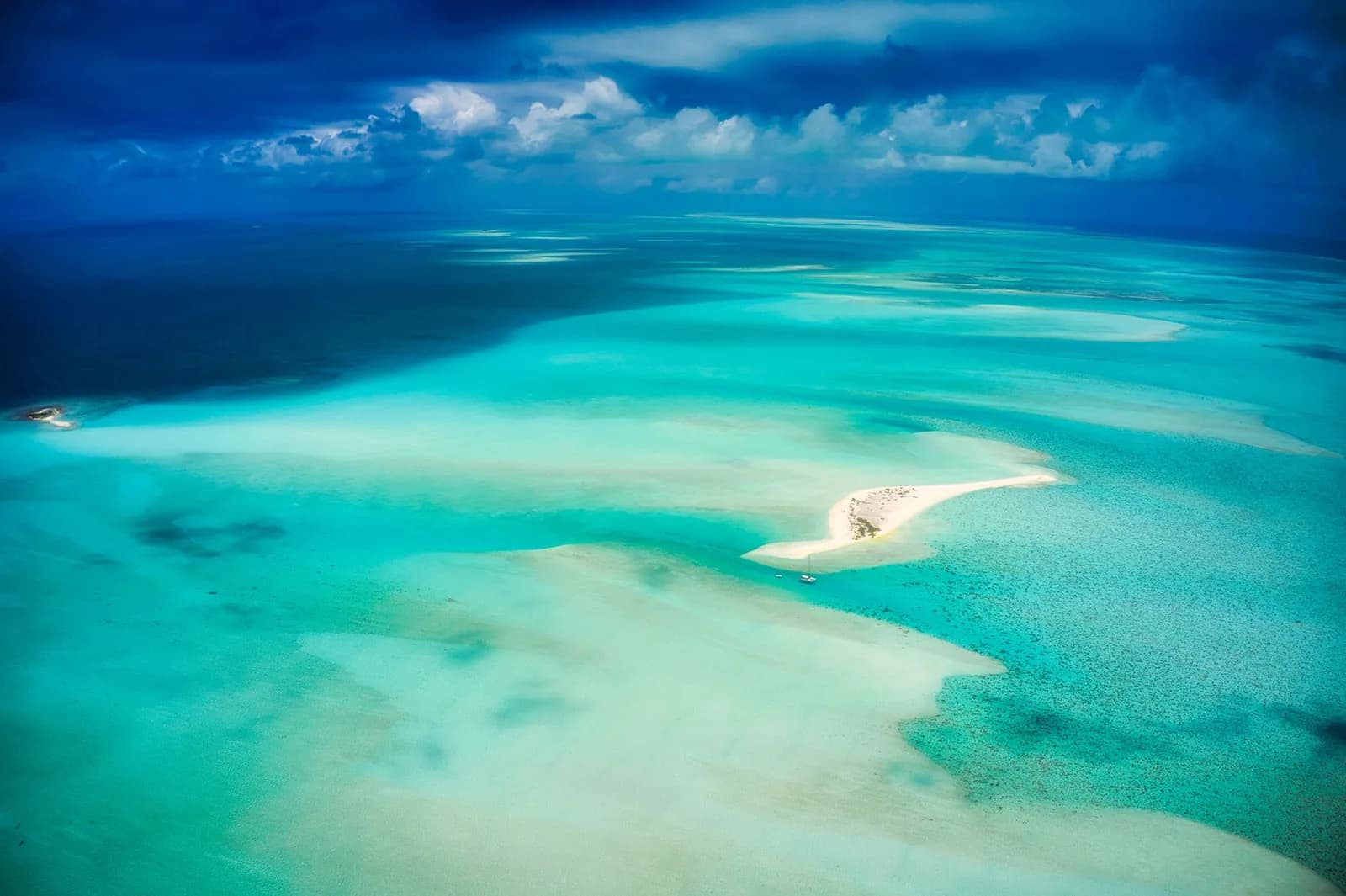 Vue aérienne d'un lagon turquoise parsemé de bancs de sable et de récifs coralliens