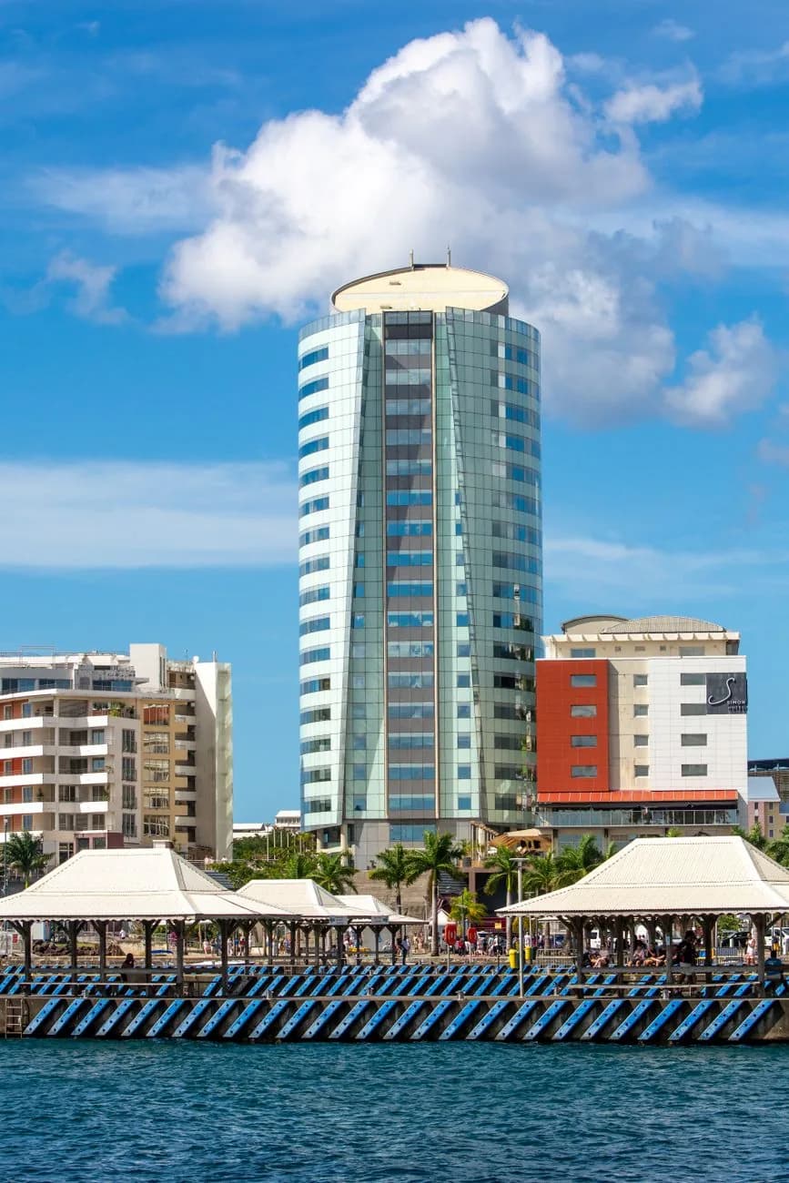 Ville côtière moderne au bord de l'océan Pacifique, avec tour vitrée et ponton en front de mer