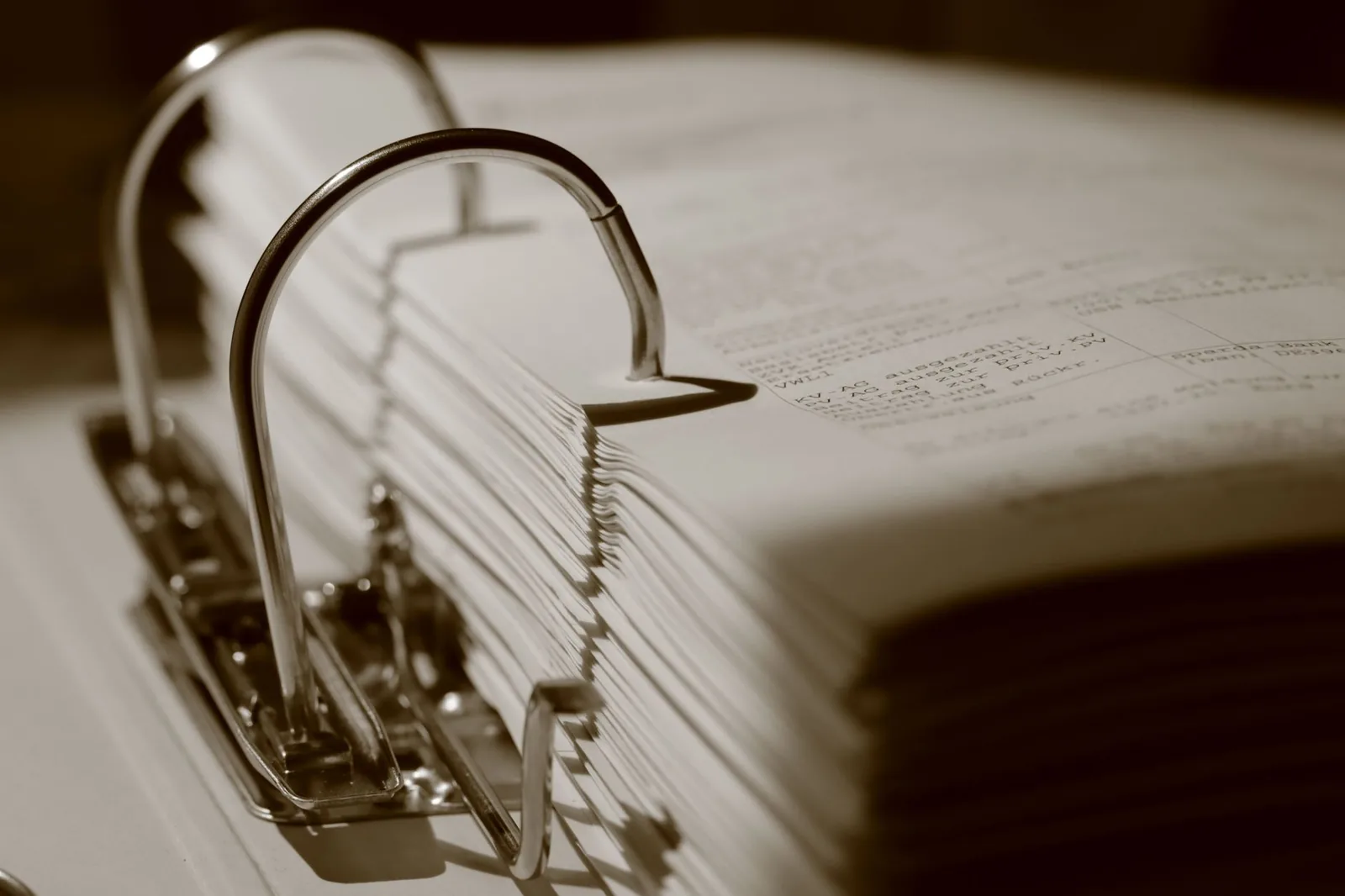 Classeur ouvert rempli de documents imprimés, illustrant un dossier et des démarches administratives