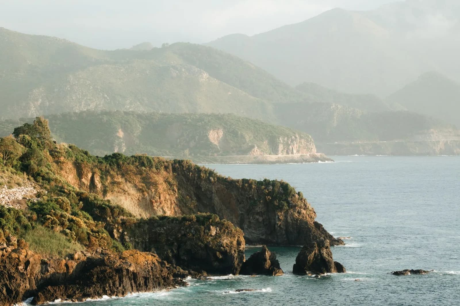 Côte rocheuse verdoyante aux collines boisées plongeant dans l'océan, région de Hienghène, Grande Terre