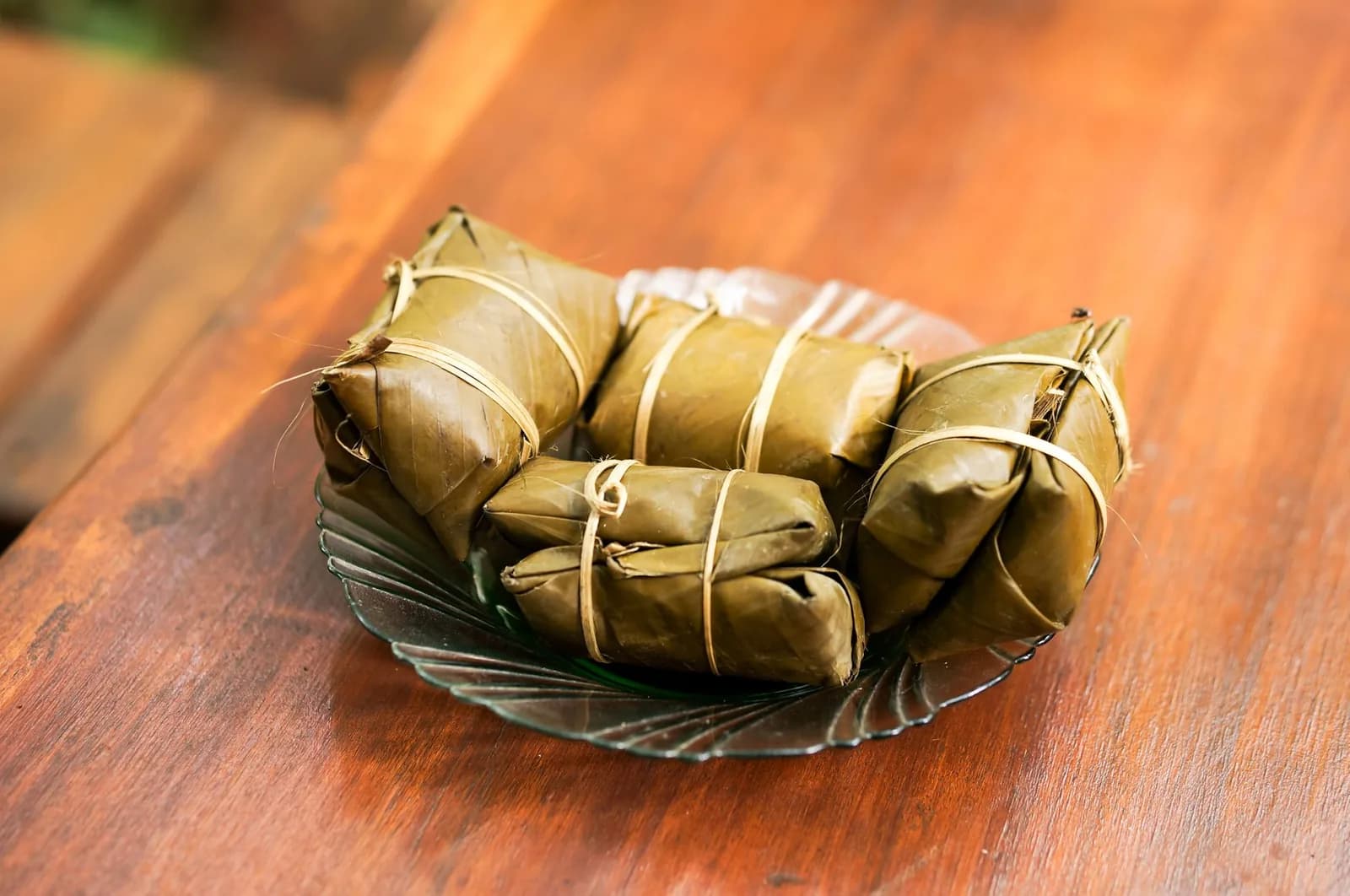 Petits paquets de nourriture cuits et enveloppés dans des feuilles, liés à la fibre, à la manière du bougna mélanésien