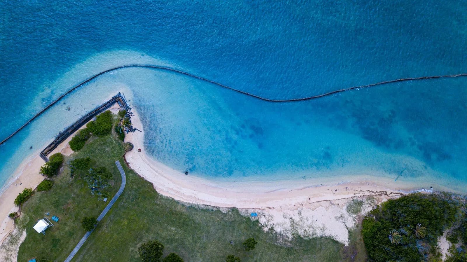 Vue aérienne d'un littoral aménagé et de son lagon turquoise, évoquant Nouméa, point de départ d'un itinéraire de deux semaines en Nouvelle-Calédonie