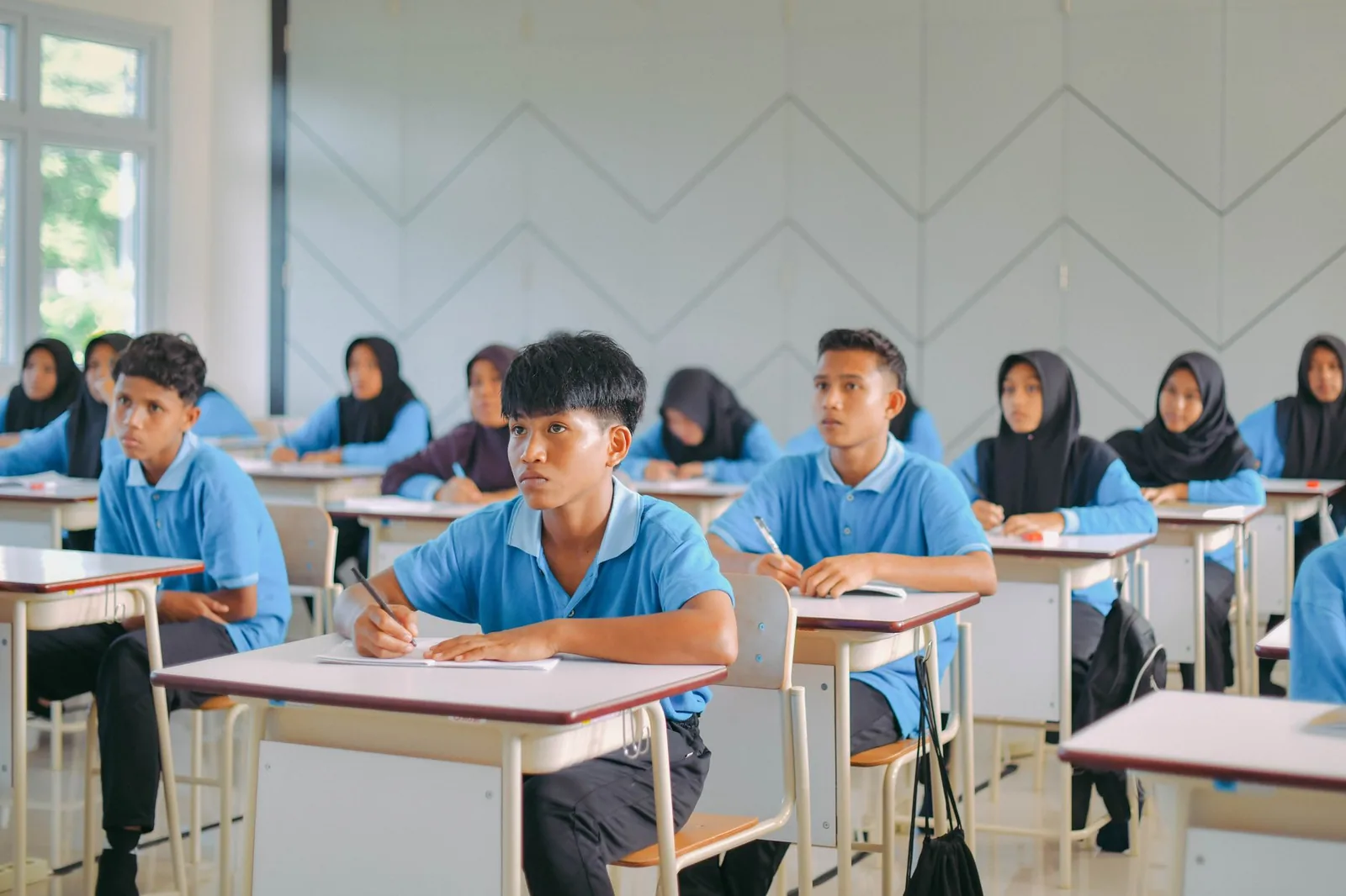 Lycéens en uniforme en cours dans une salle de classe (photo d'illustration, non localisée)
