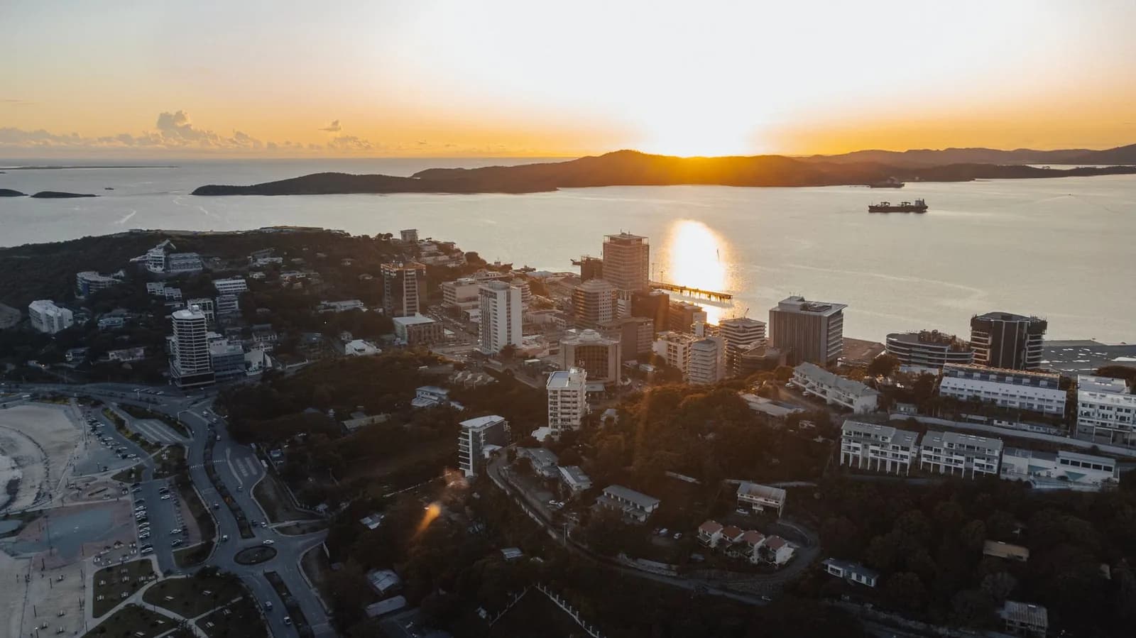 Vue aérienne d'une ville côtière du Pacifique au coucher du soleil (image d'illustration, pas Nouméa)
