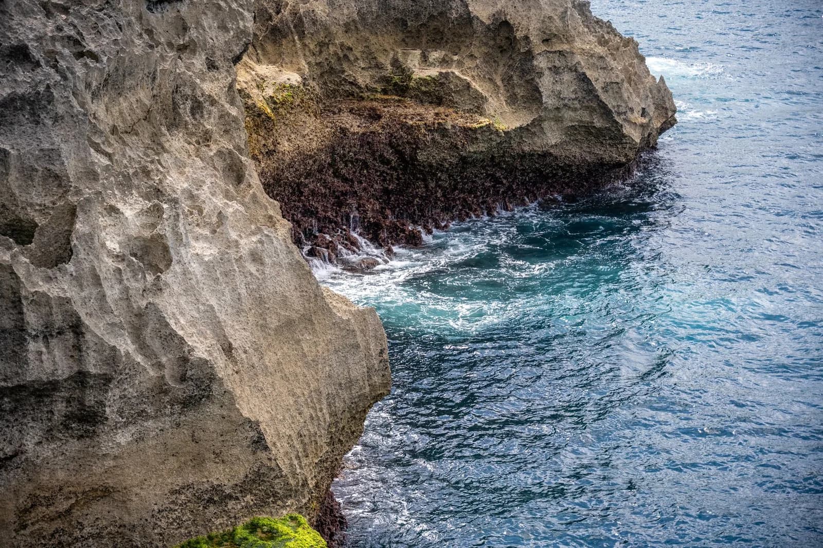 Rocher calcaire coiffé de végétation cerné d'un lagon turquoise, ambiance sauvage des îles Loyauté