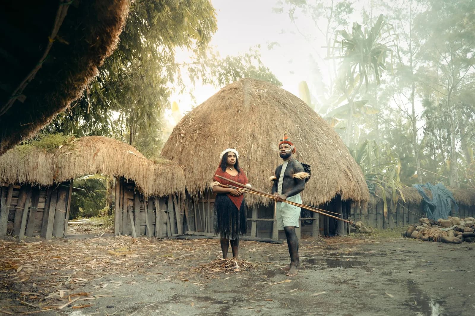 Cases traditionnelles au toit de chaume et habitants en tenue coutumière dans un village mélanésien, patrimoine culturel du Pacifique