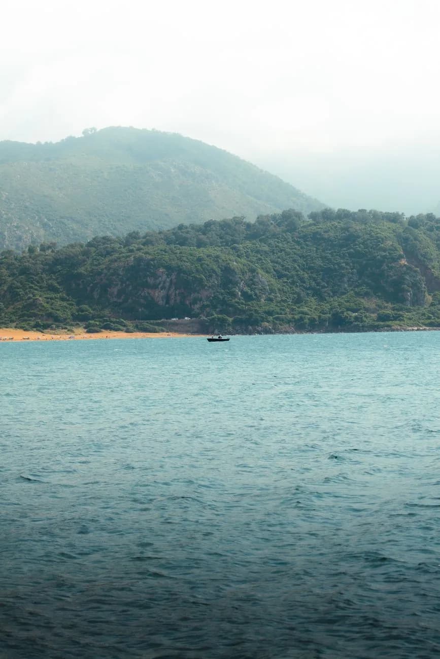Collines verdoyantes plongeant vers une baie et l'ocean bleu, photo d'illustration evoquant une cote verte et son littoral
