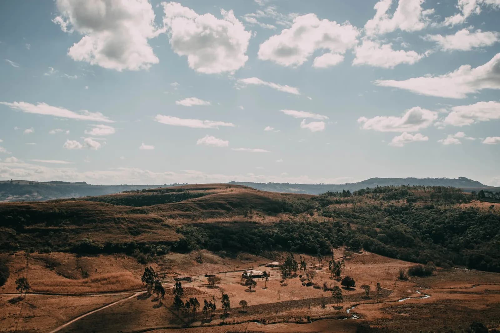 Collines sèches et brousse rurale avec un élevage isolé, paysage semblable à l'intérieur de la province Sud de la Nouvelle-Calédonie