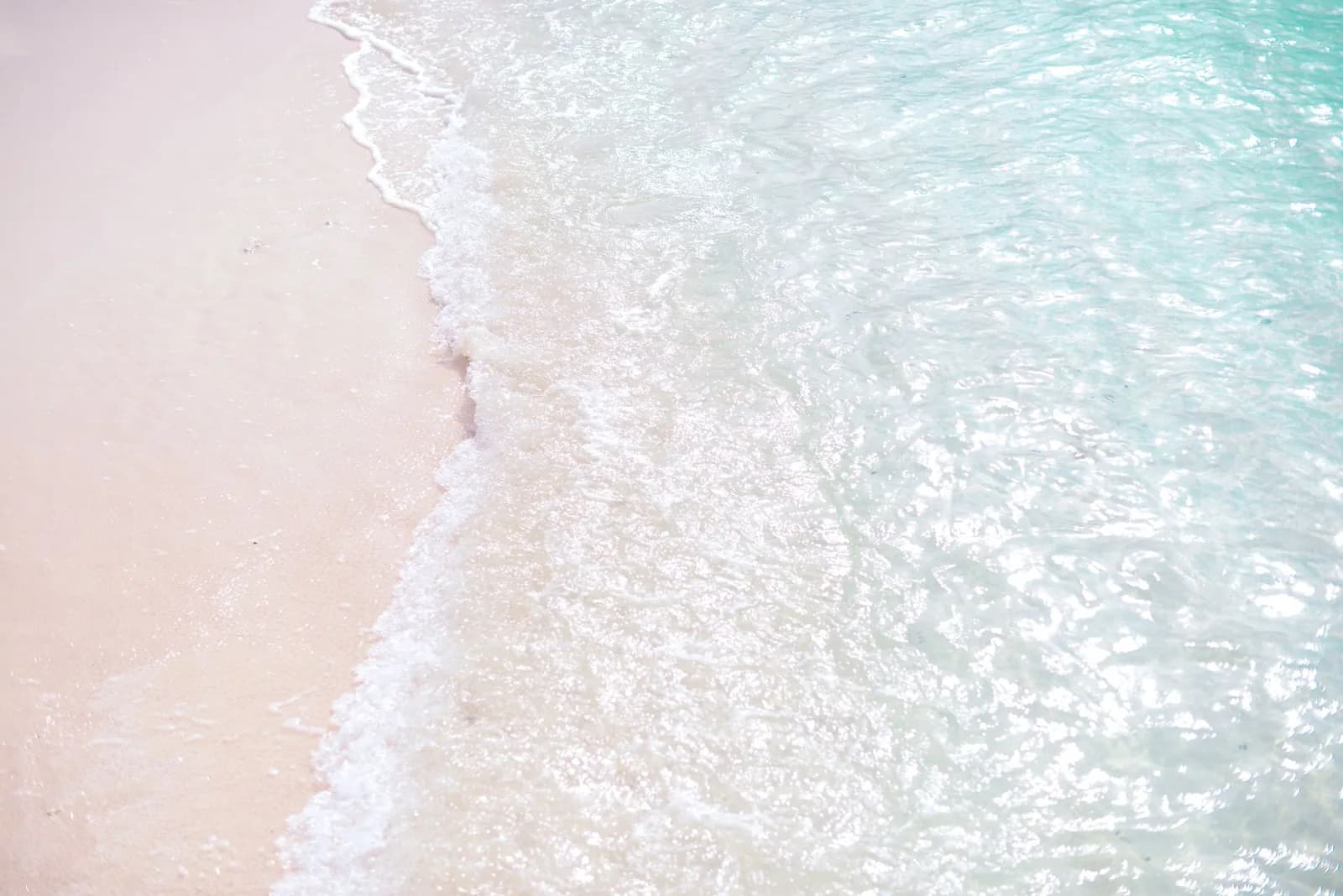 Lagon tropical aux eaux turquoise bordé d'une île de cocotiers sous un ciel bleu dégagé, ambiance typique de la saison sèche