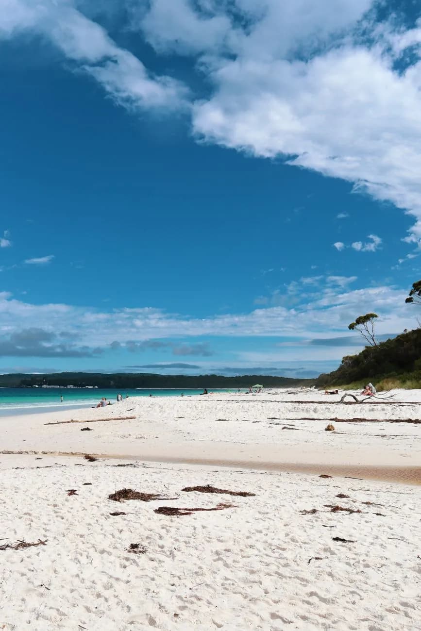 Plage de sable blanc et eaux turquoise sous un ciel bleu