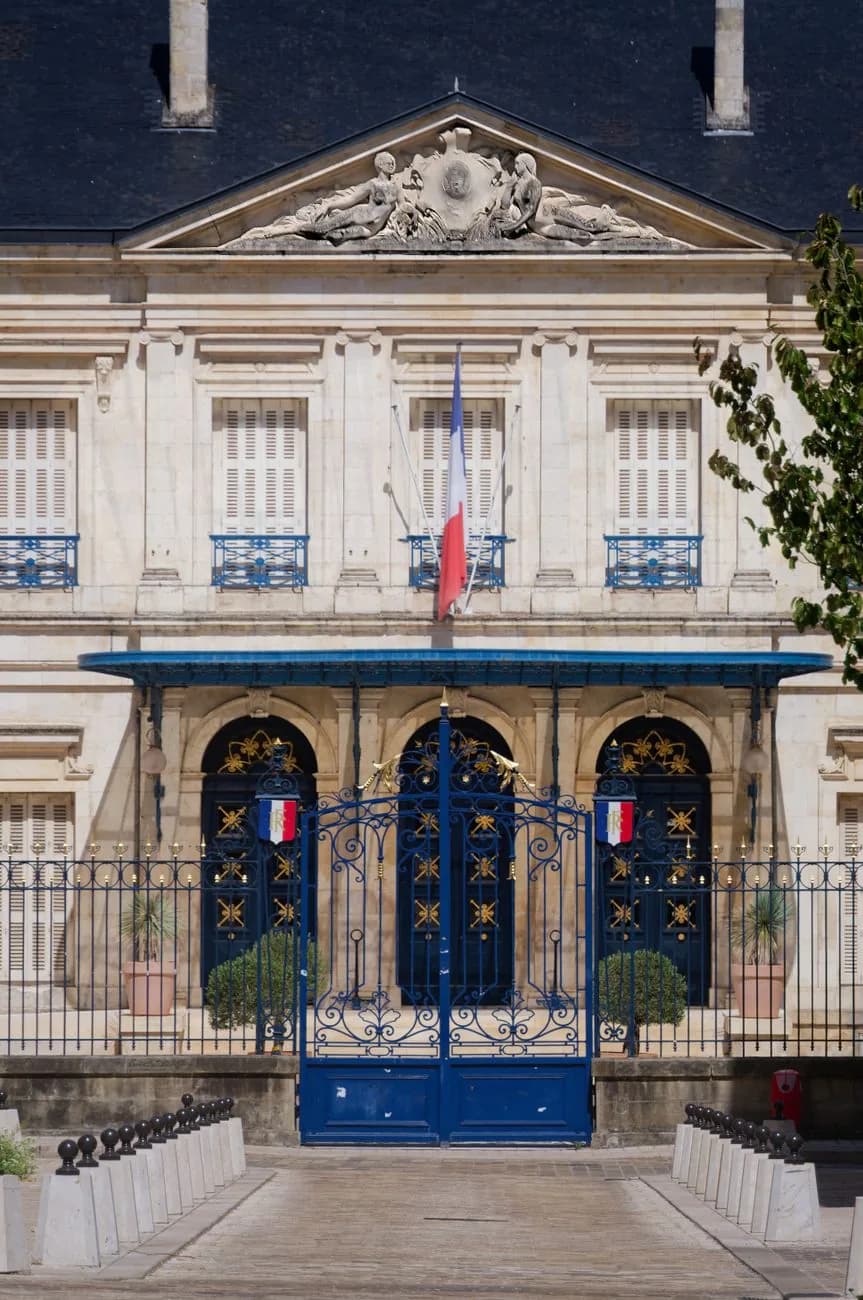 Drapeau tricolore français sur la façade d’un bâtiment officiel, évoquant le lien institutionnel entre la Nouvelle-Calédonie et l’État français