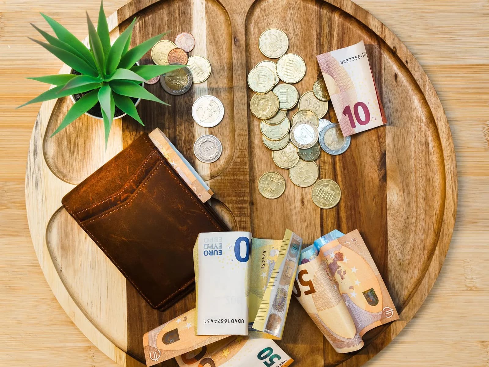Billets et pièces en euros posés sur une calculatrice, illustration du calcul d'une rémunération