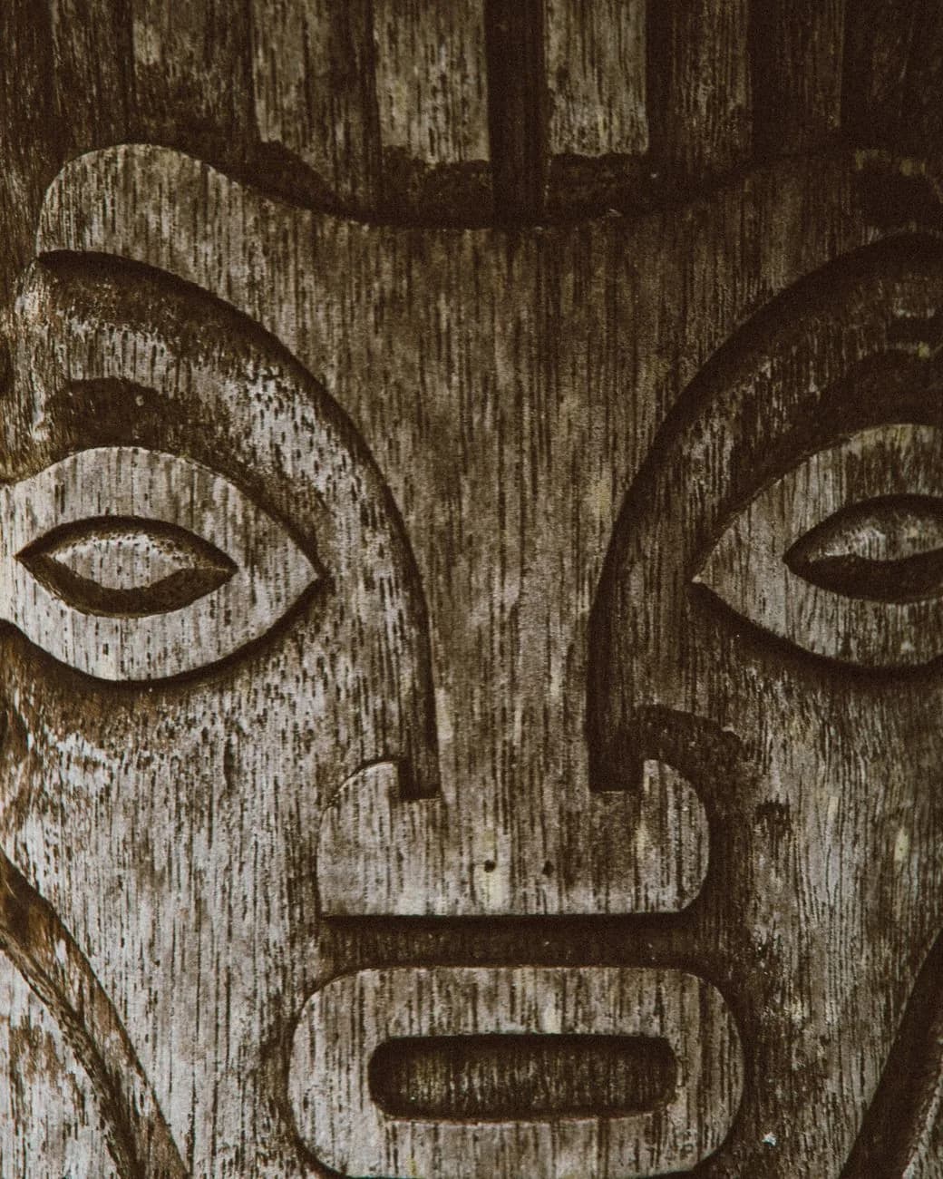 Un visage sculpté dans le bois vieilli, art traditionnel de la sculpture du Pacifique
